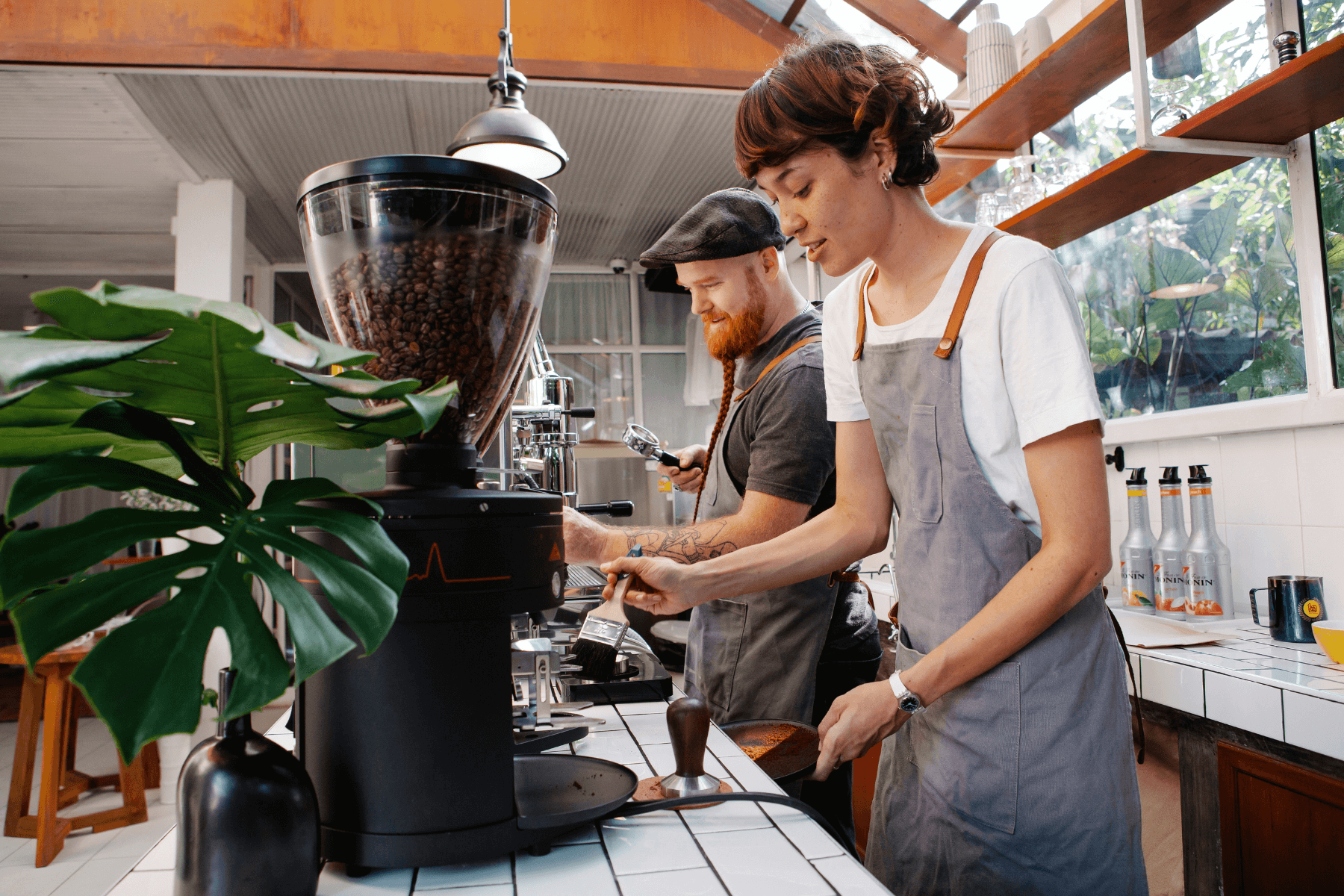 Two baristas making coffee in an open cafe